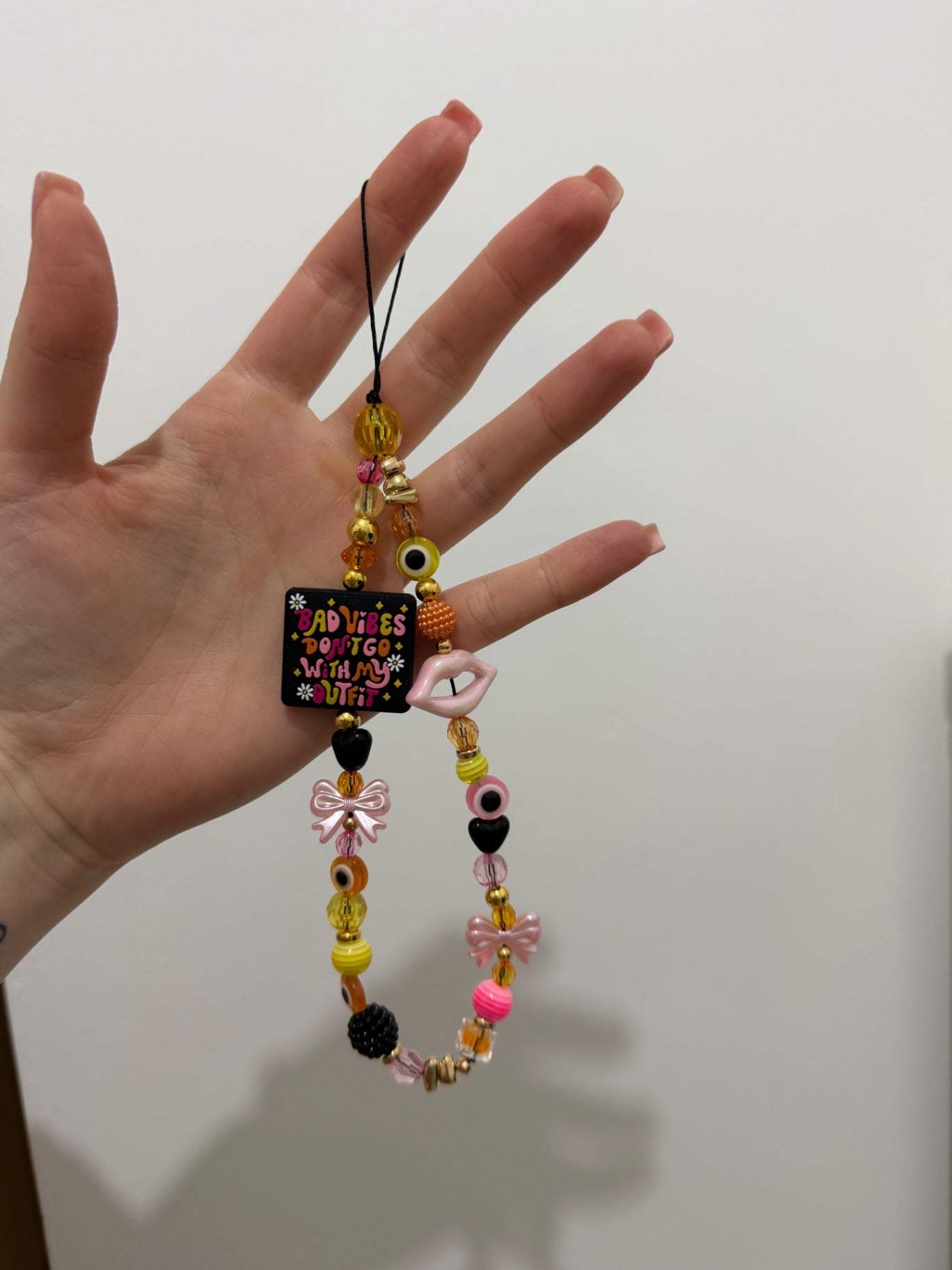 ‘Bad vibes don’t go with my outfit’ phone charm - gold