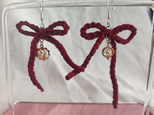 Crochet burgundy bows with golden sparkly charms
