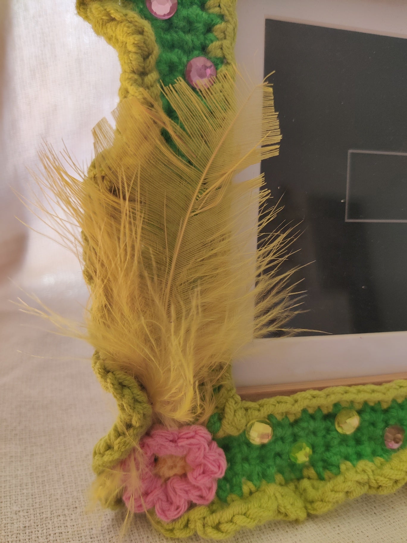 Crochet green photo frame wit feathers